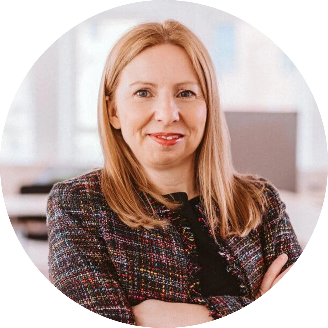 Nadine Schönwald, in einer bunten Jacke mit verschränkten Armen