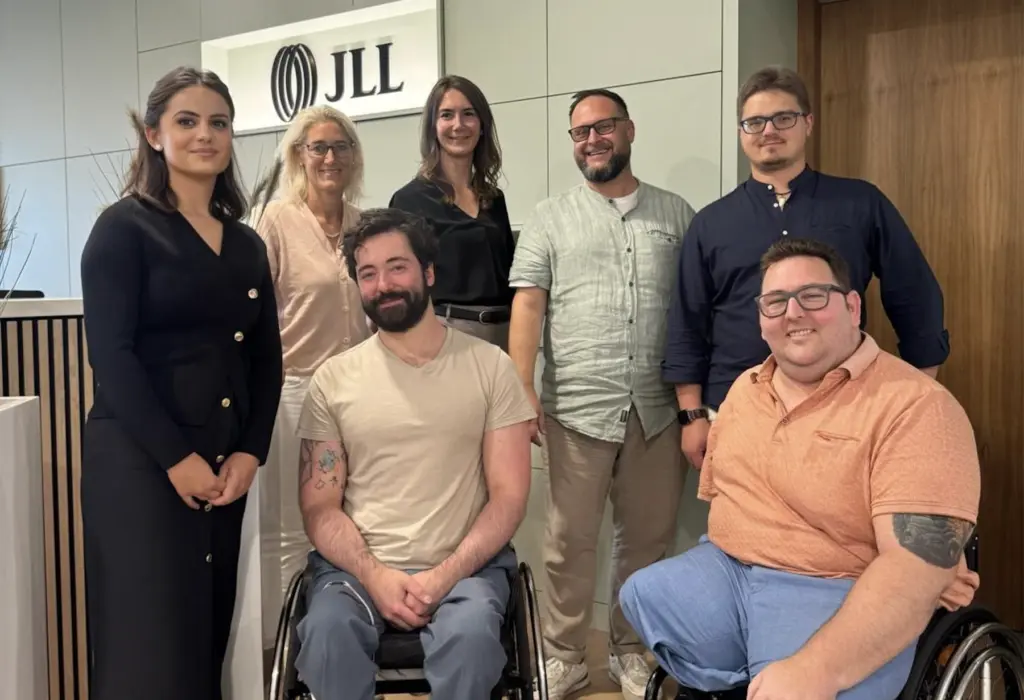 Insgesamt 7 Personen vom Inklusionsfit Institut und Jones Lang LaSalle posieren auf dem Foto und verkünden die gemeinsame Partnerschaft